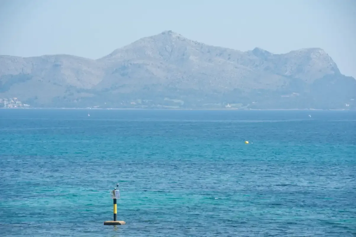 A coastal seascape with blue water and mountains across the bay.