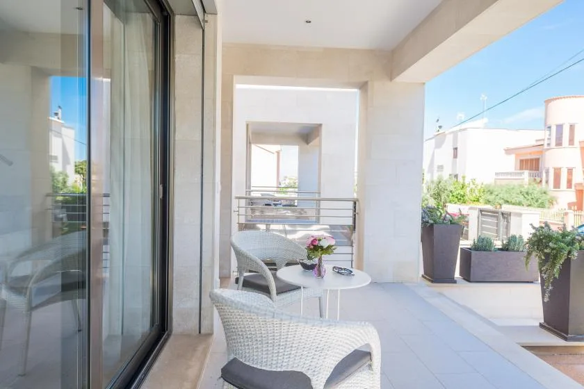 A bright balcony seating area with a small table and potted plants.