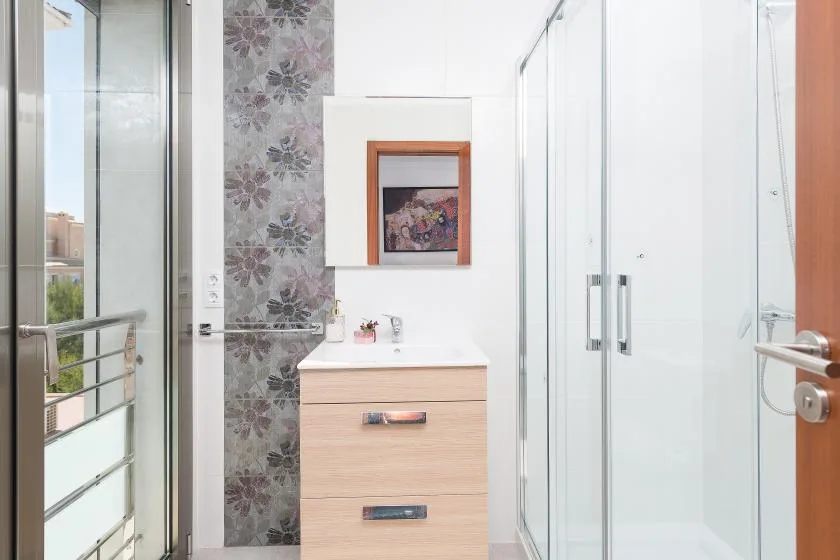 A bright bathroom with a vanity and glass shower.