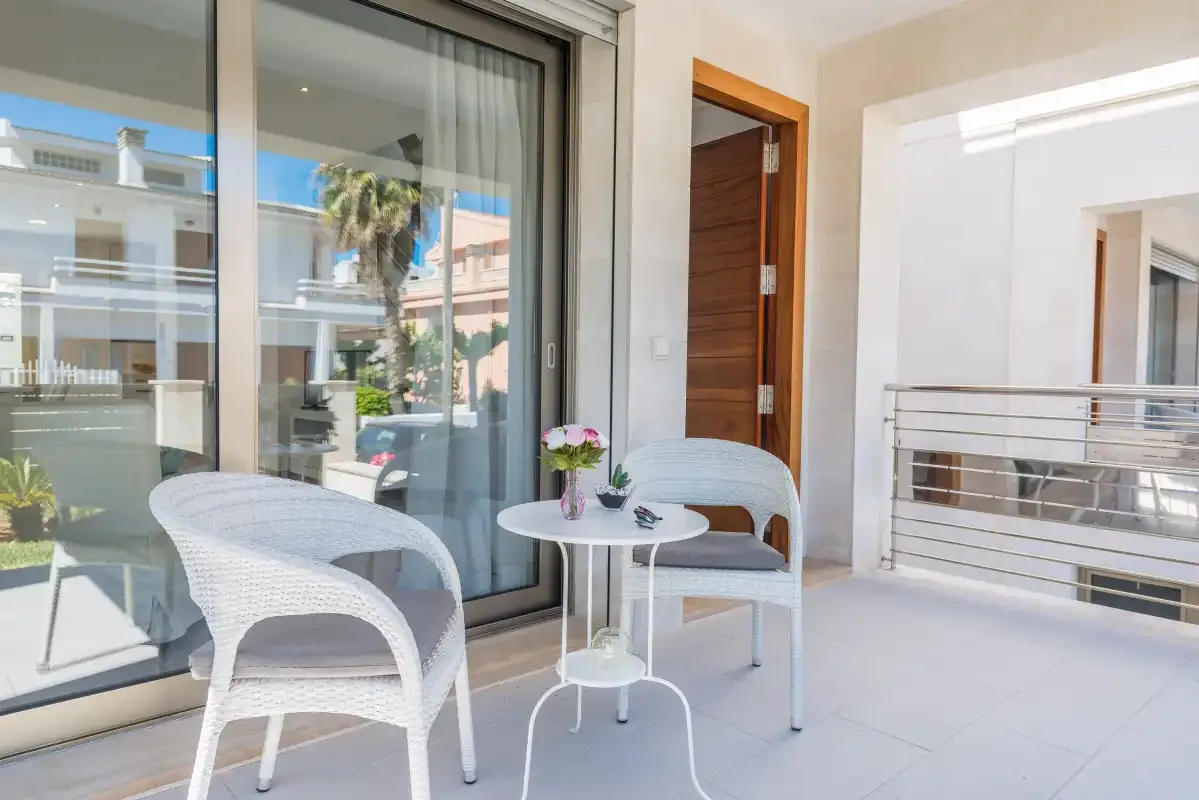 A bright patio seating area with a small round table beside sliding glass doors.
