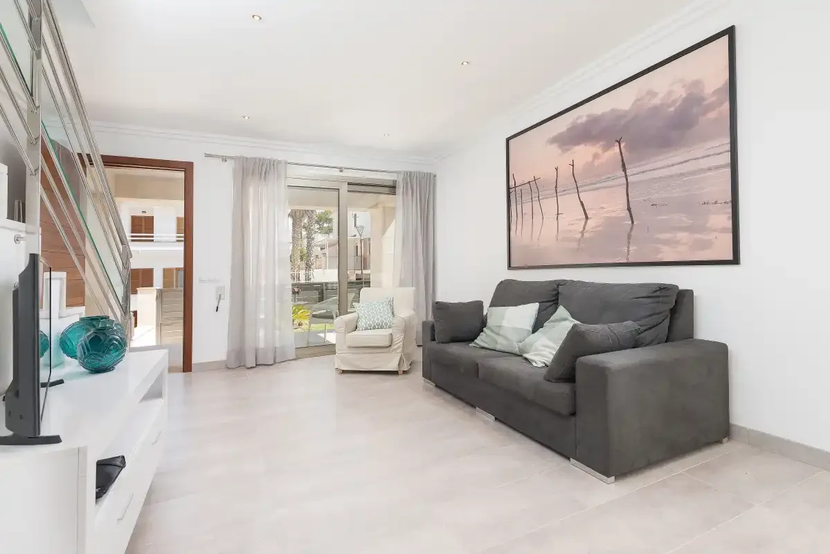A bright living room with gray seating and a large framed picture.