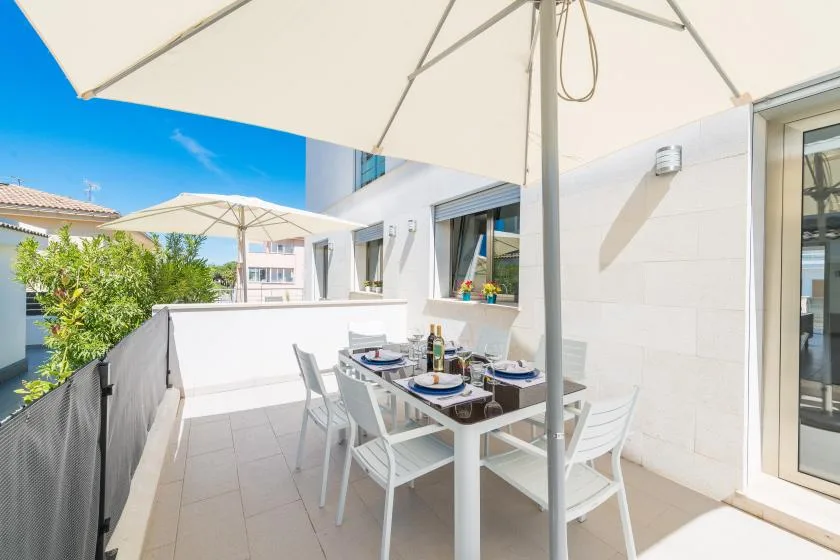 A tiled outdoor dining area sits beneath a large patio umbrella.