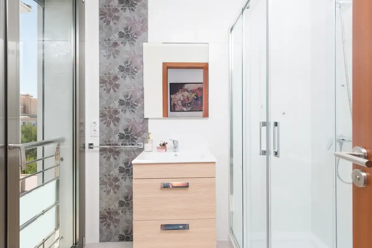 A bright bathroom with a vanity and glass shower.