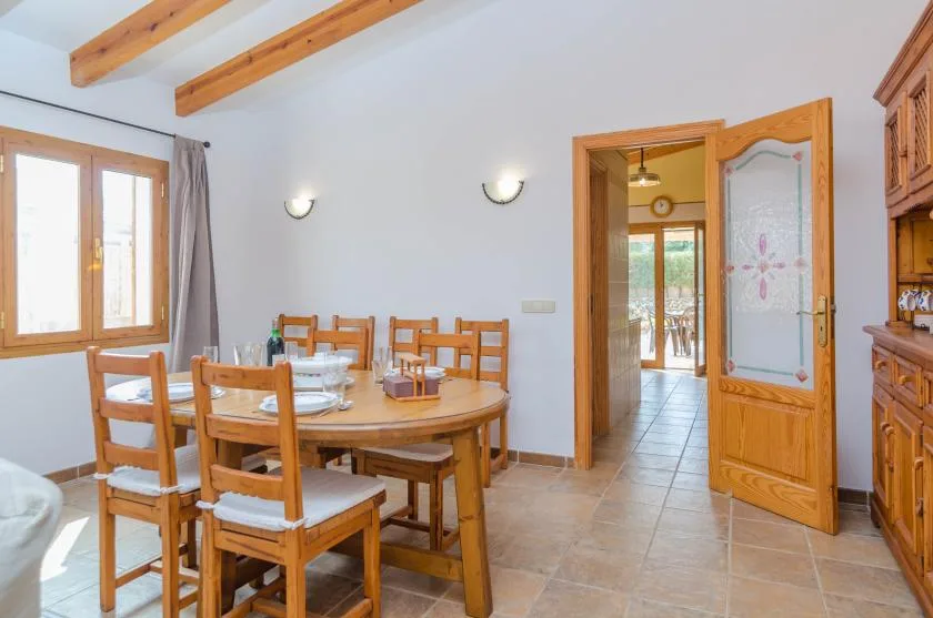 A dining area with a wooden table and chairs beside a window.