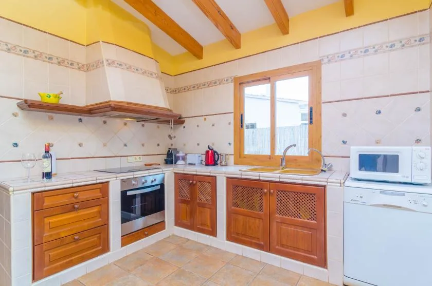 A bright kitchen with wooden cabinets, a countertop, and a window above the sink.