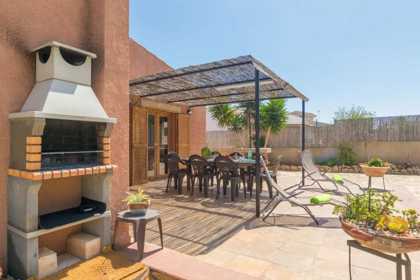 A sunny patio with outdoor seating, a shaded dining area, and a built-in barbecue.