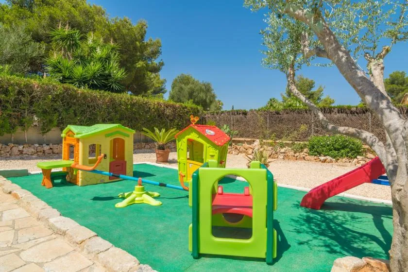 A colorful outdoor playground with small play structures on a green surface.