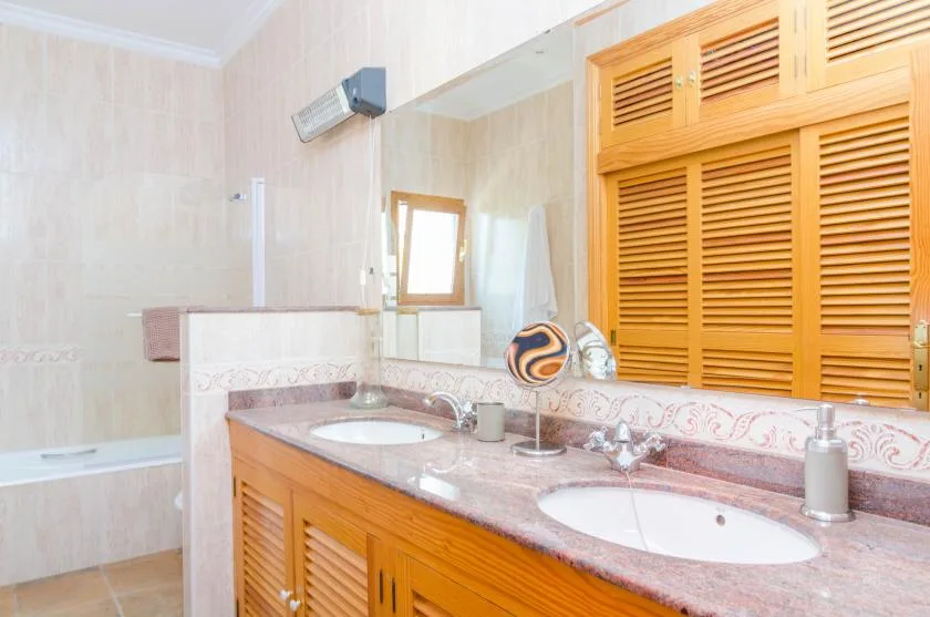 A bathroom vanity with two sinks and wooden cabinets.
