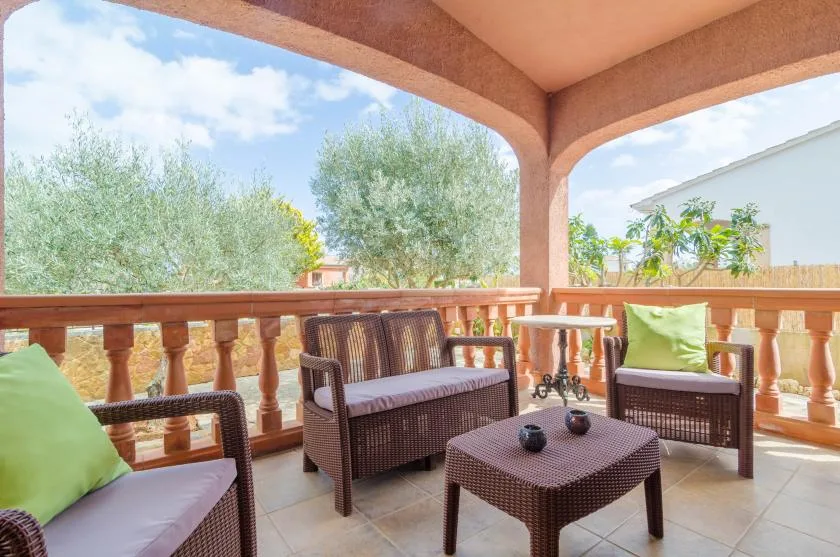 A covered outdoor seating area overlooks trees and greenery.