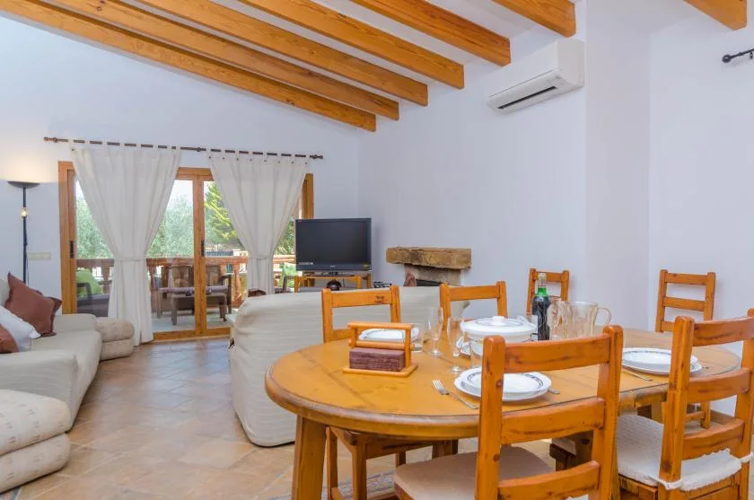 A dining area with a wooden table and chairs beside a living room.