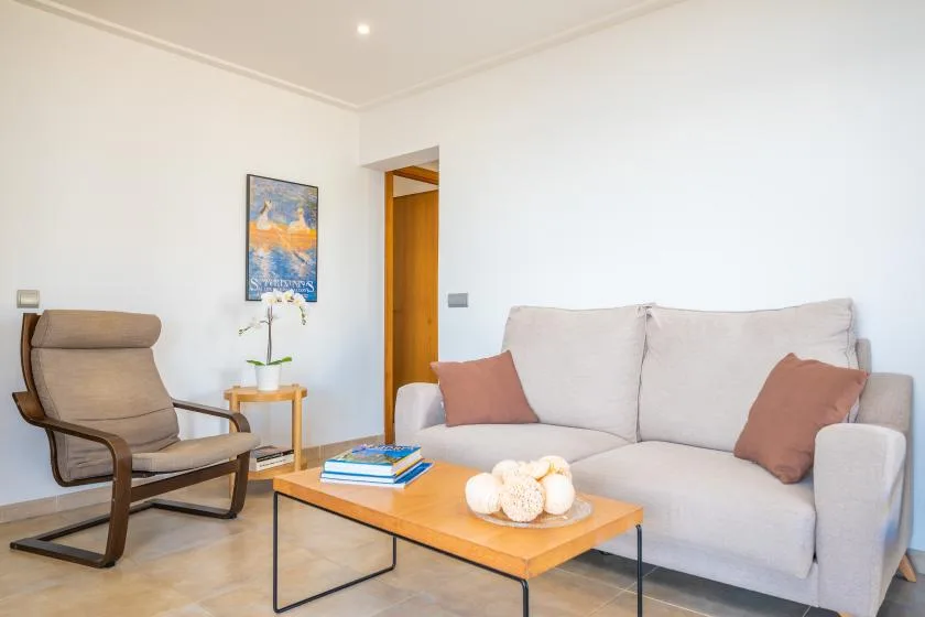 Una sala de estar luminosa con asientos alrededor de una mesa de centro de madera.