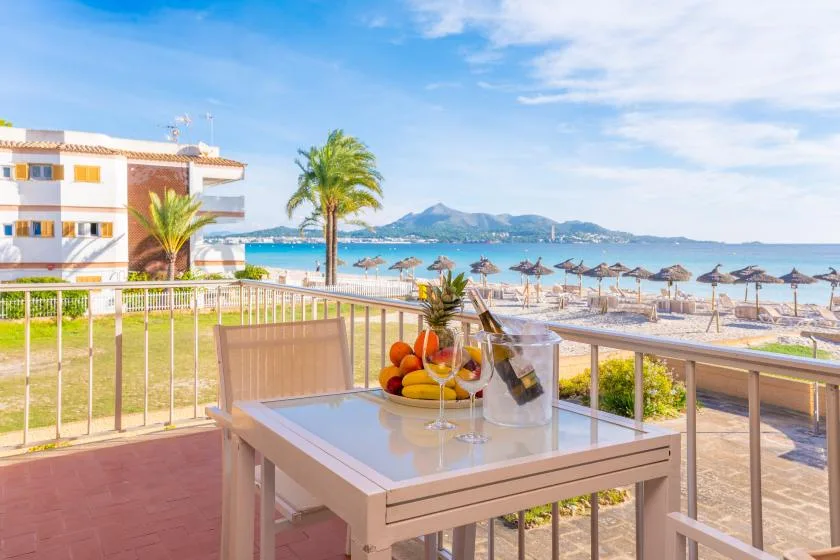 Una terraza junto al mar con una mesa frente a la playa y la bahía.