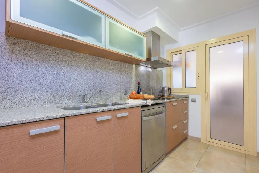 Una cocina con gabinetes de frente de madera, una encimera y un horno.