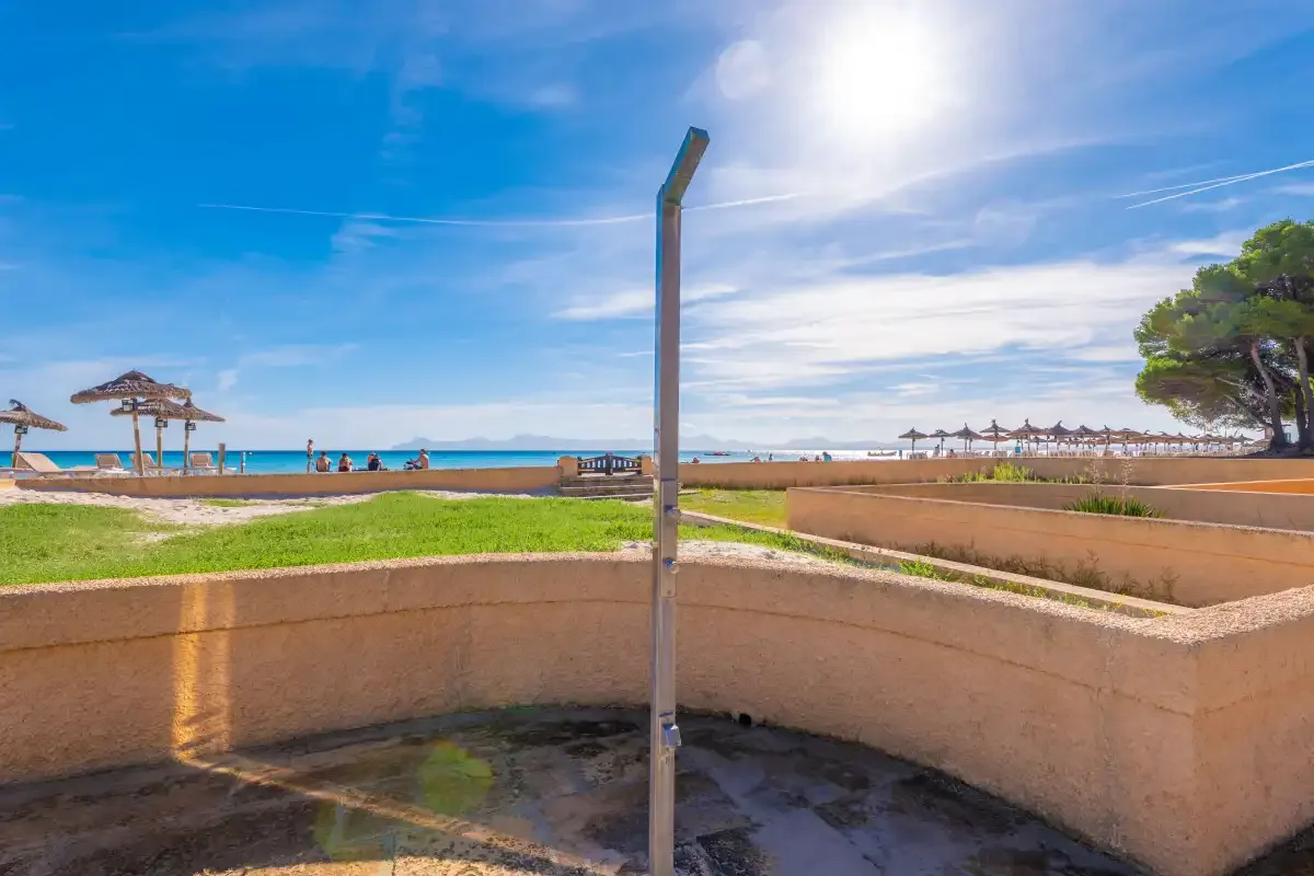 Una ducha exterior junto a la playa da a la arena y al mar.