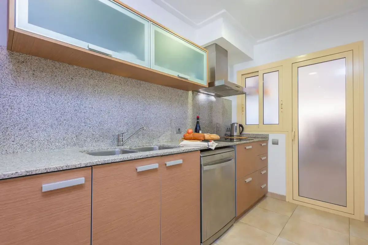 Una cocina con encimera, fregadero y horno integrado.