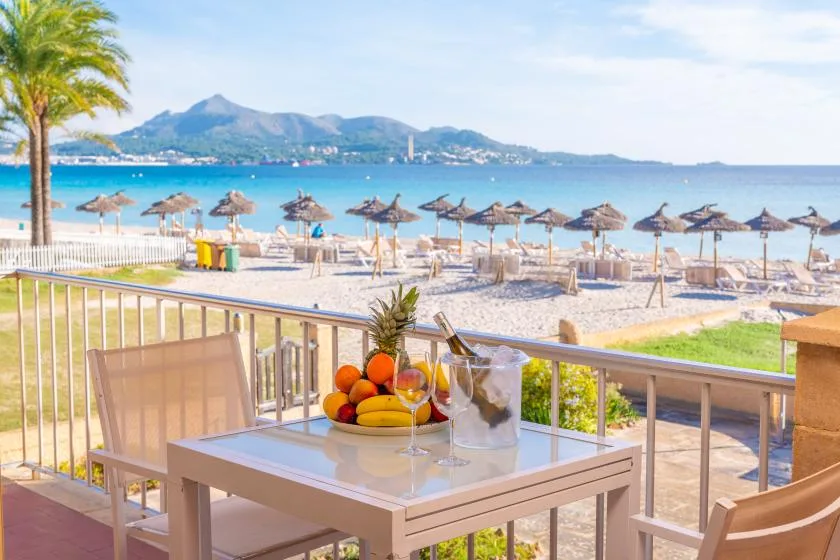 Una mesa en un patio junto al mar mira hacia la playa y el agua.