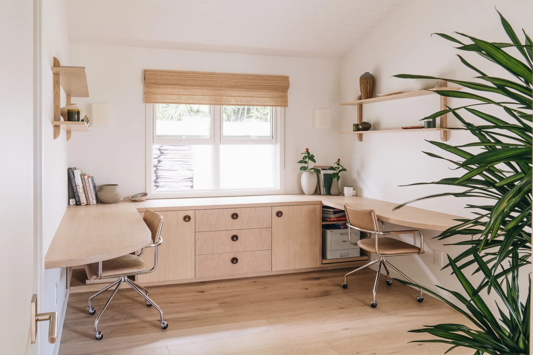 A bright home office with built-in desks and a window.