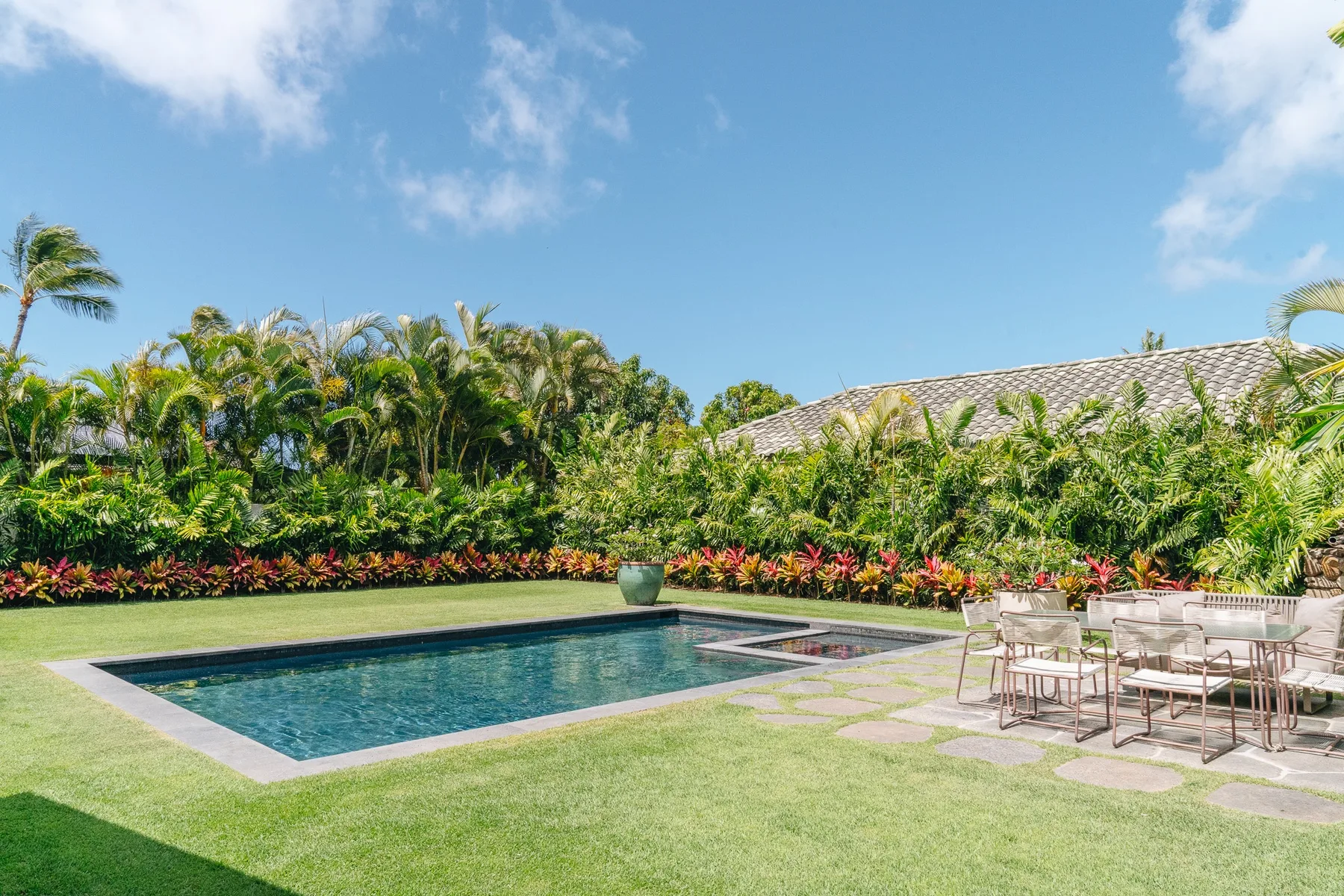 A garden patio with a swimming pool and outdoor seating.