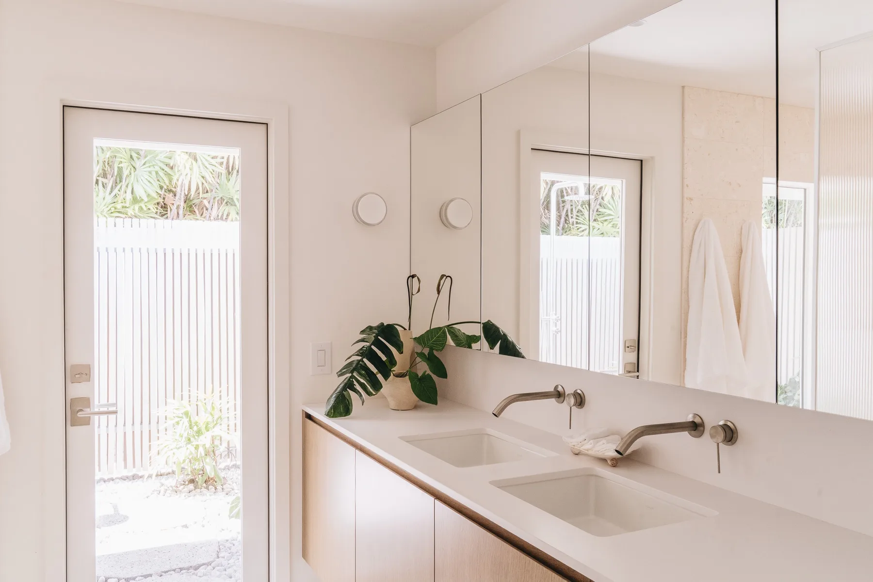 A bright bathroom with a double sink vanity and large mirror.