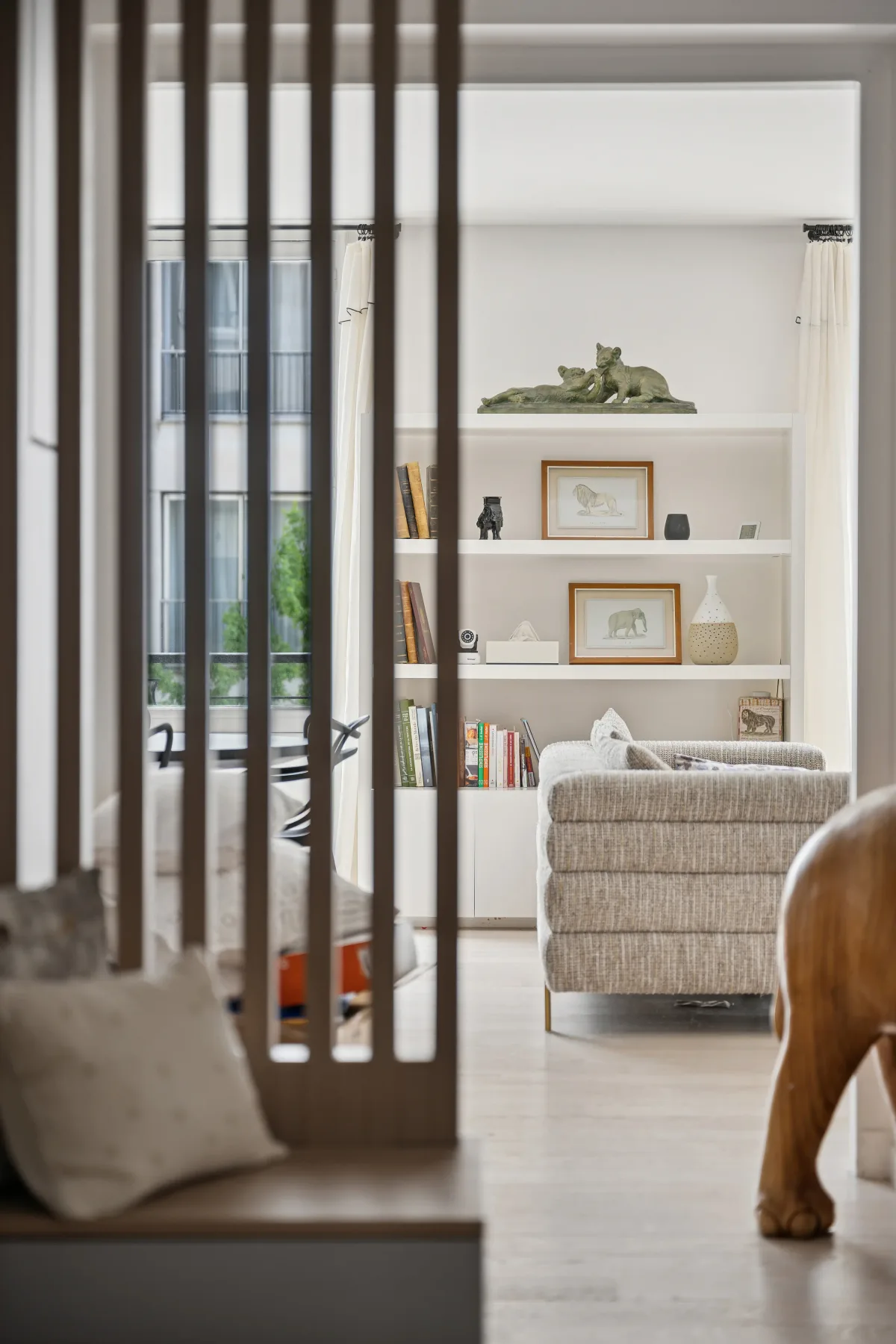 A bright living room with built-in shelves and upholstered seating.