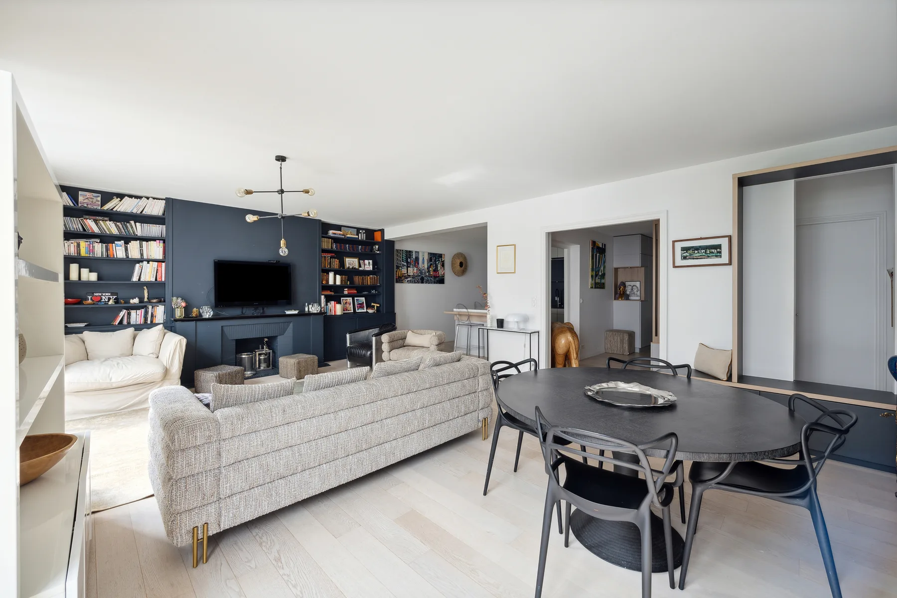A bright living and dining area with seating, a television, and a dining table.