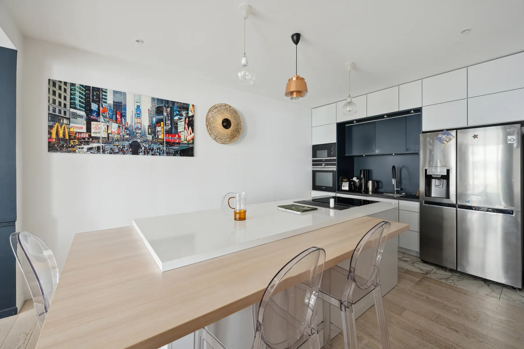 A modern kitchen with a large island and stainless-steel appliances.