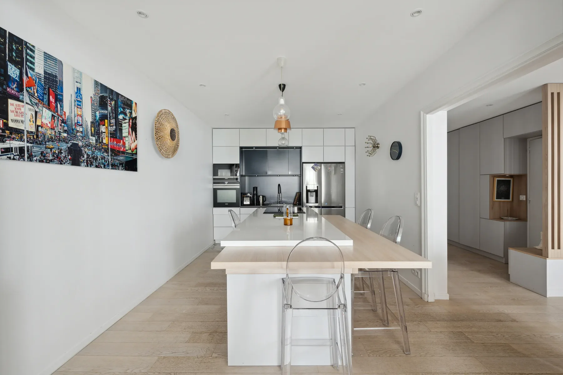 A bright kitchen and dining area with a long island and wall art.