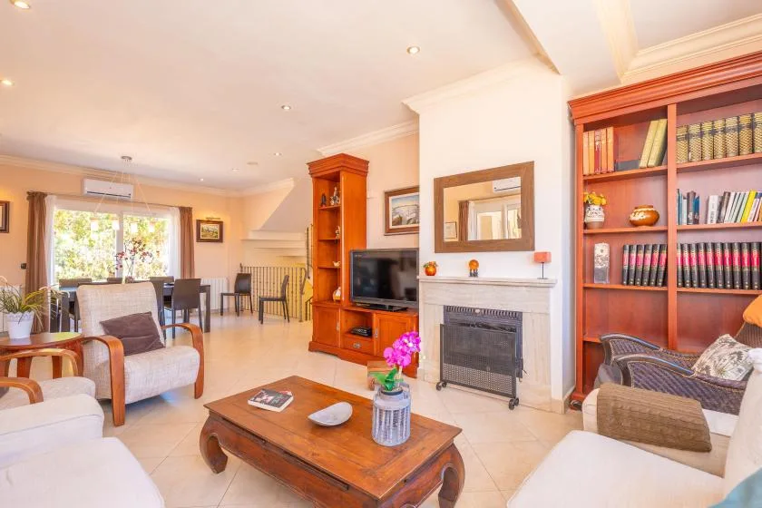 Una sala luminosa con asientos alrededor de una mesa de centro de madera y una chimenea.