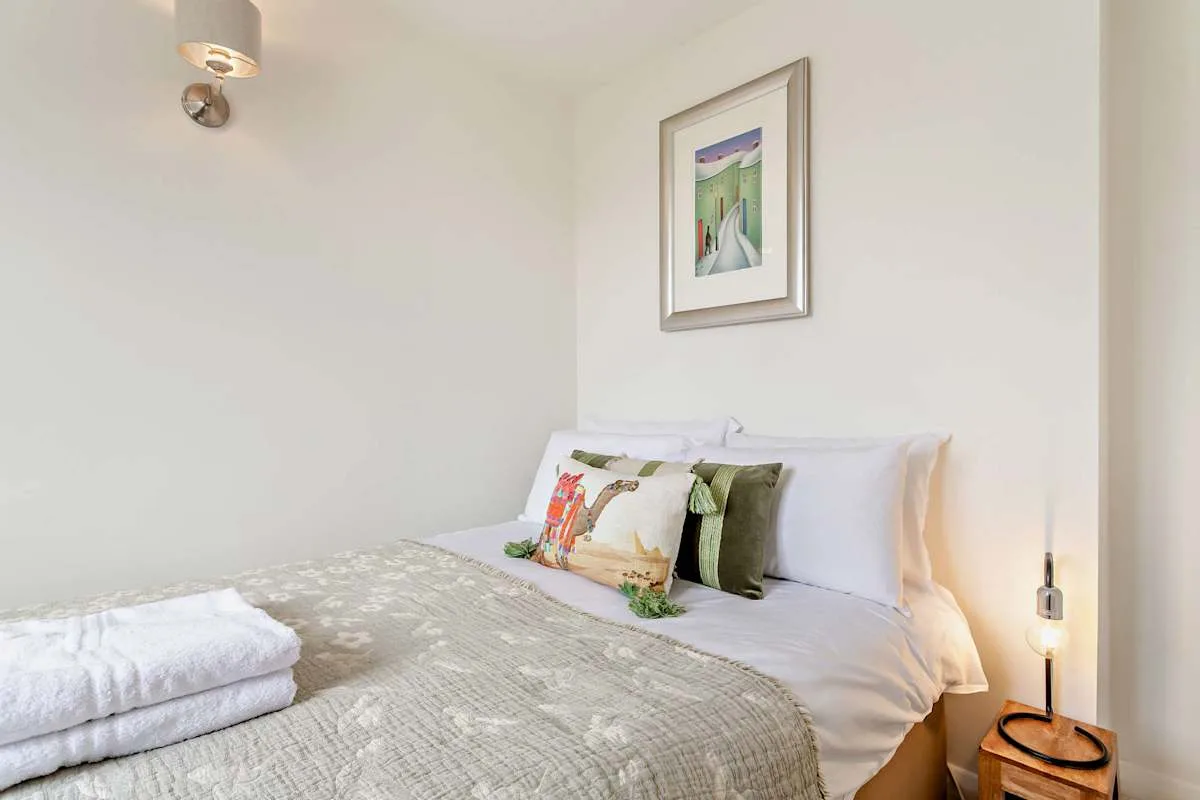 A neatly made bedroom with patterned bedding and decorative pillows.