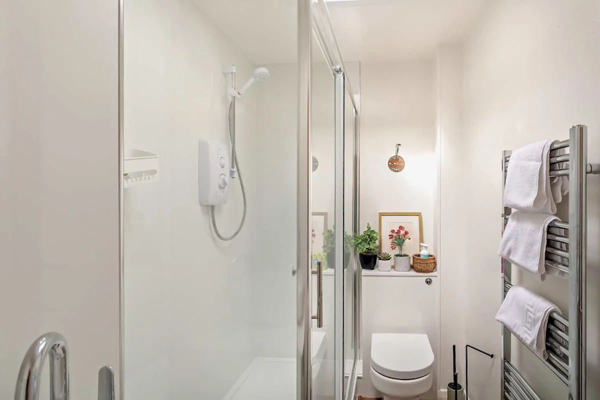 A bright bathroom with a shower and toilet.