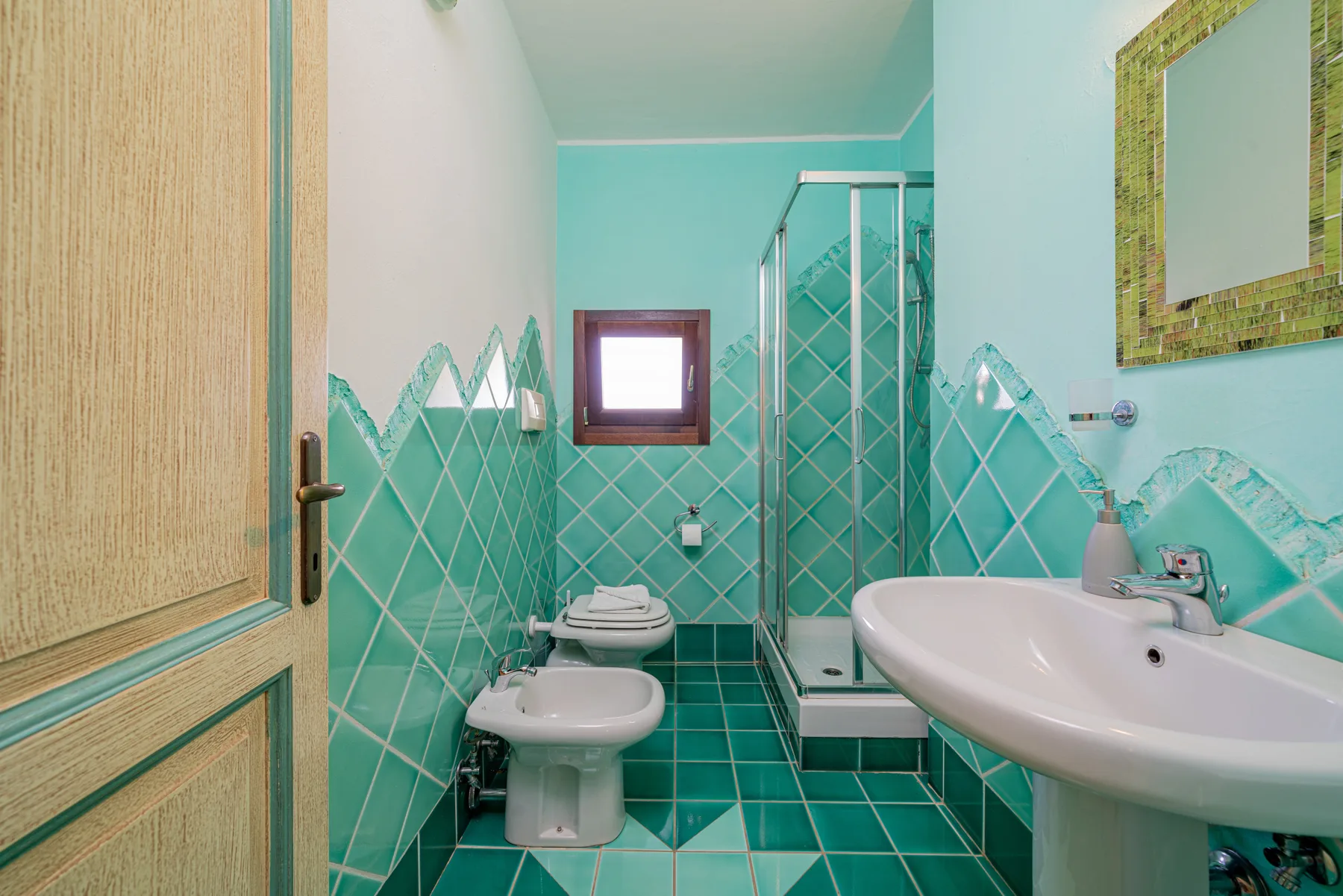 Un baño alicatado con bañera, inodoro y ducha.