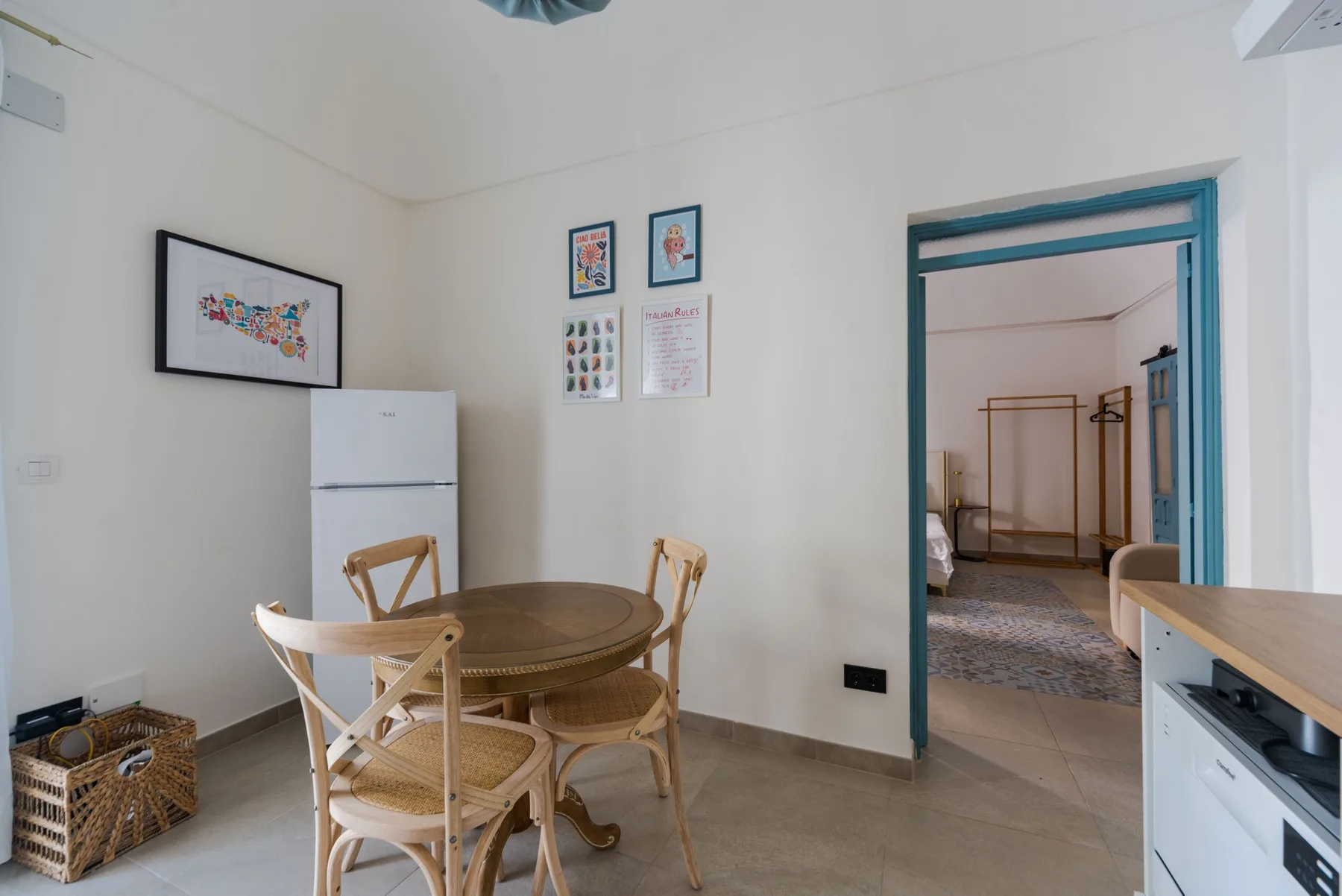 Comedor con una mesa redonda y sillas junto a un refrigerador.