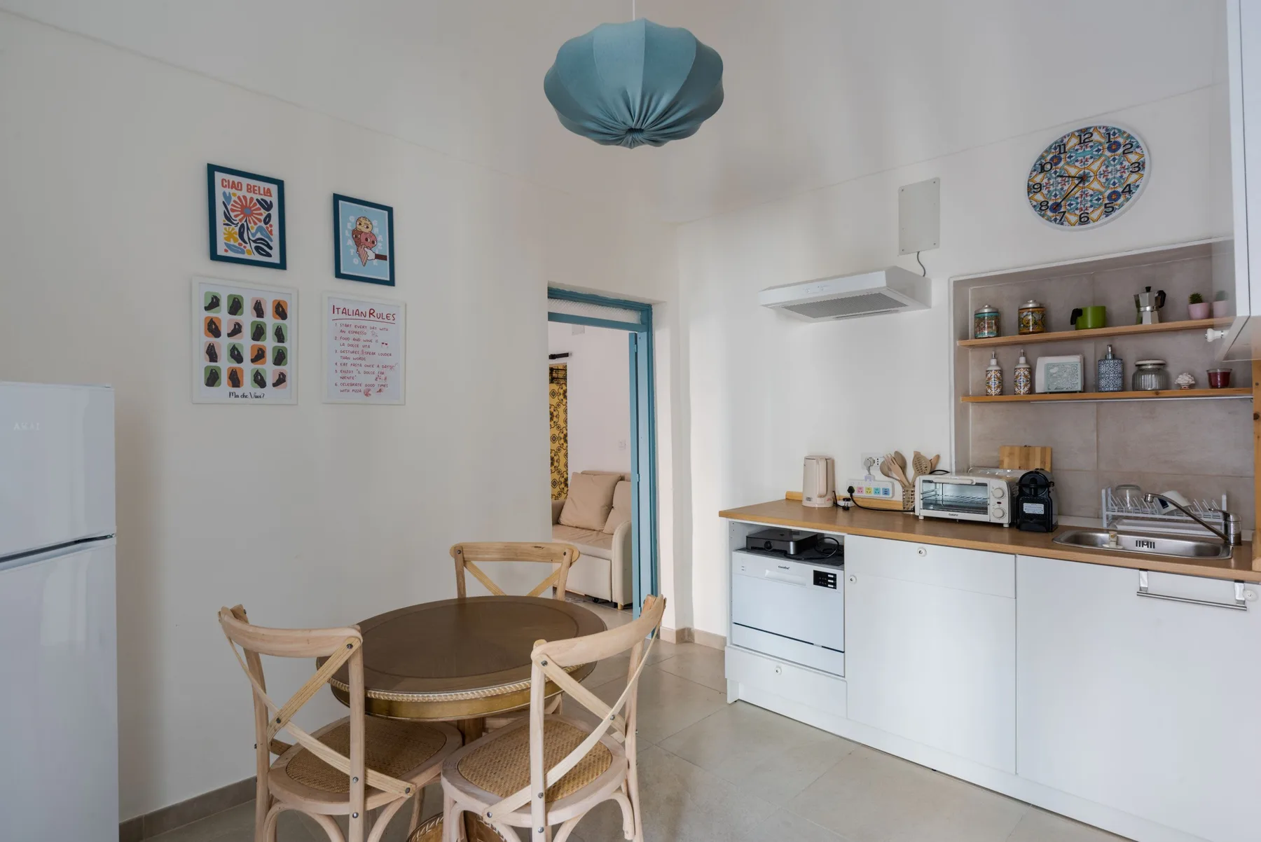 Un comedor luminoso con una mesa redonda junto a una cocina compacta.