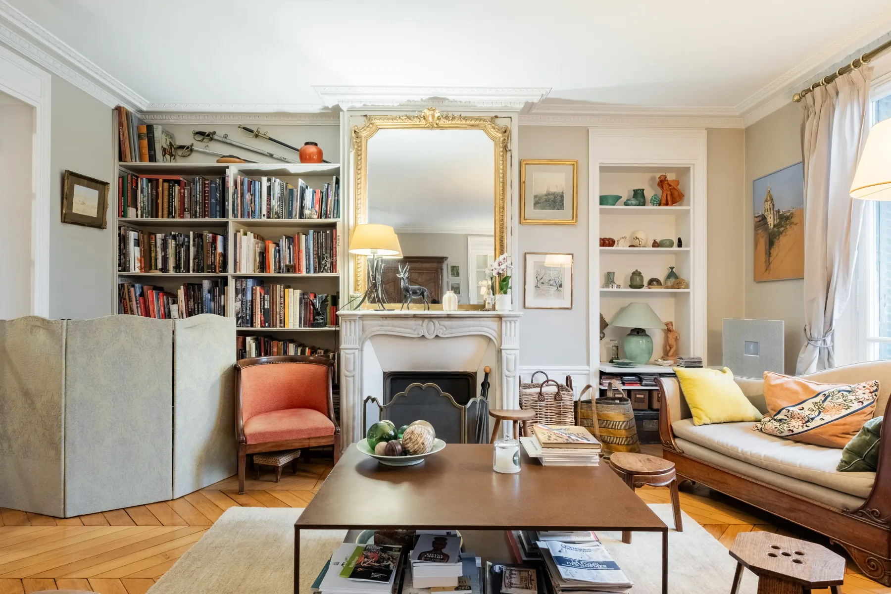 A bright living room with a fireplace, bookshelves, and seating.