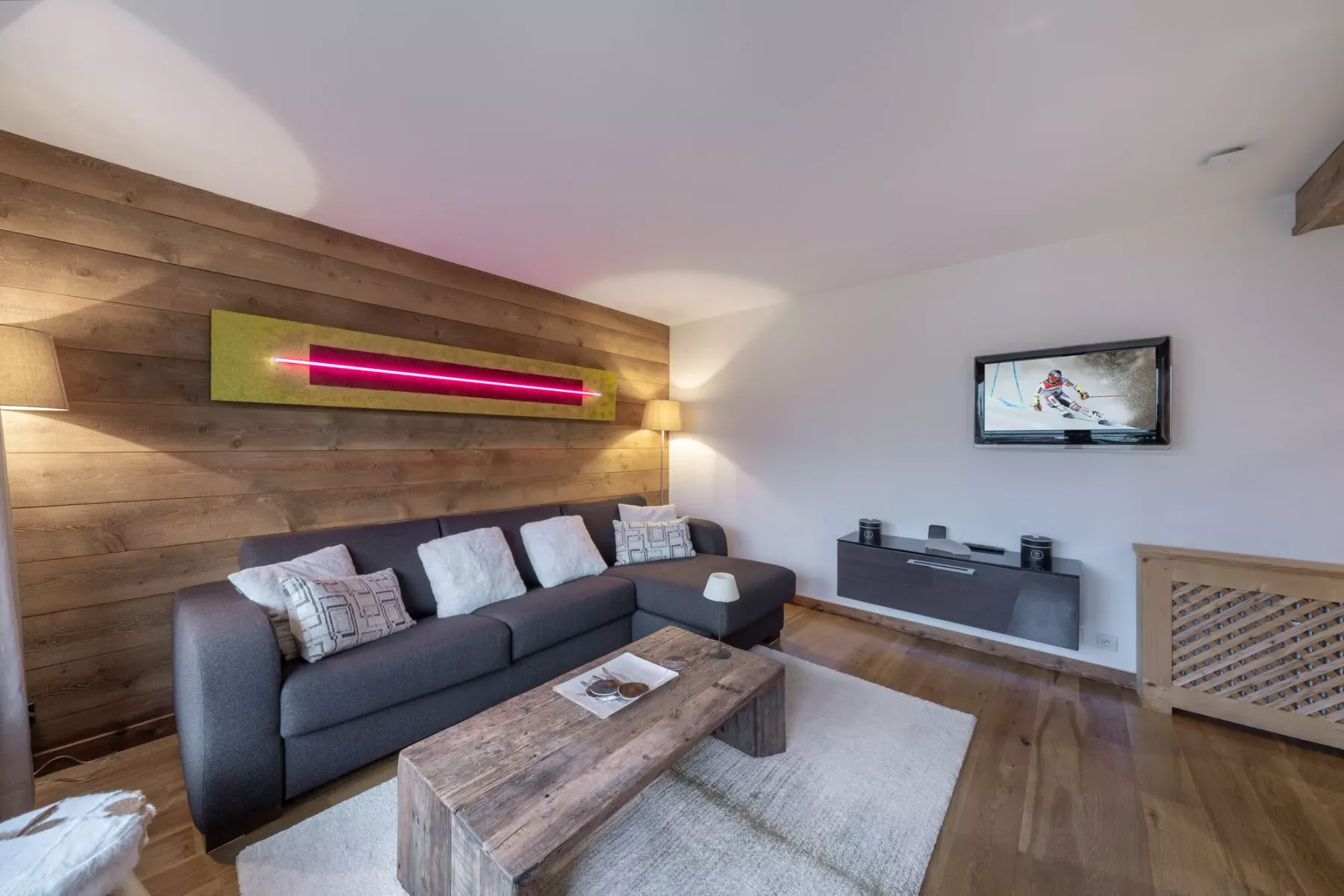 Living room with a seating area, coffee table, and television.