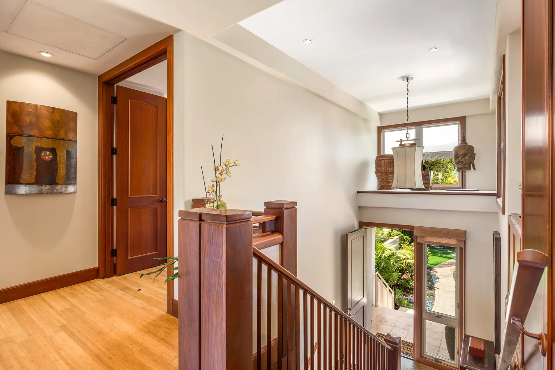 A bright interior landing overlooks a staircase and a tall window.