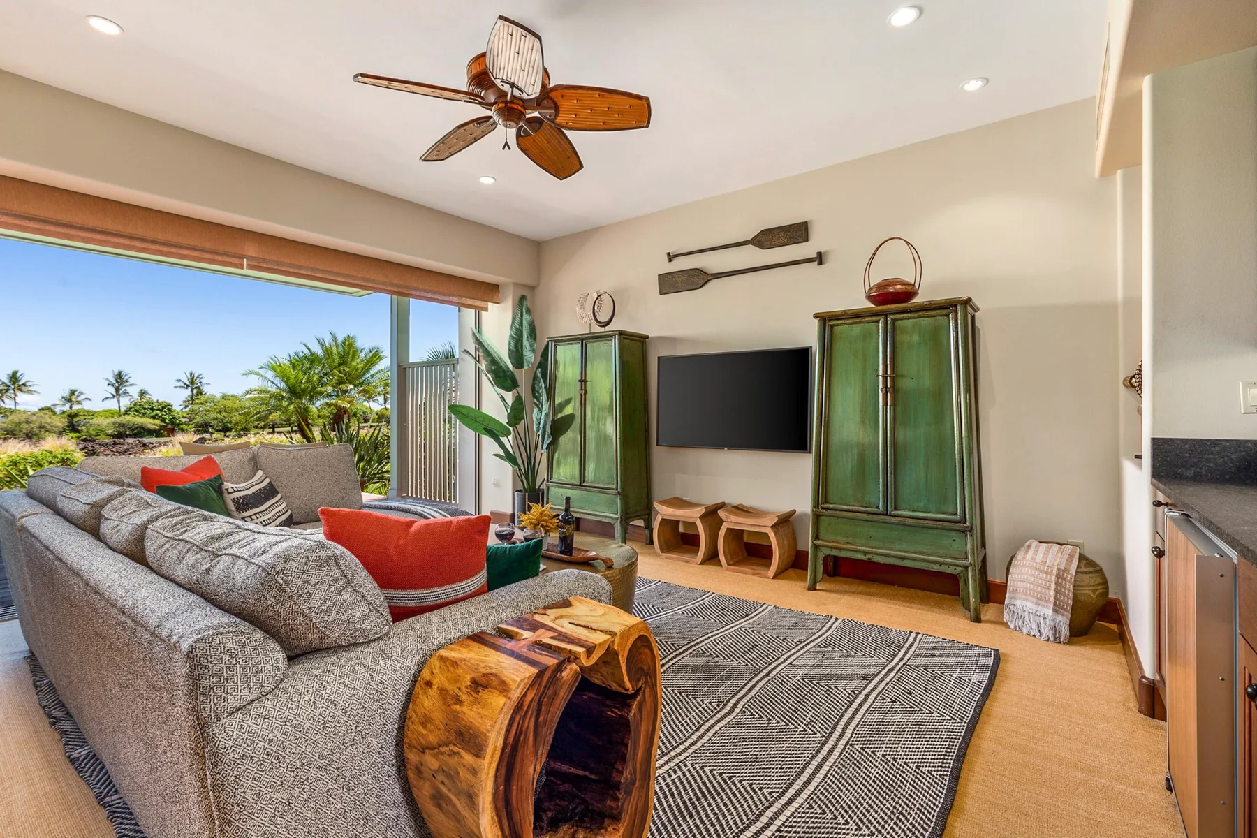 A living room with gray seating, a television, and sliding glass doors.