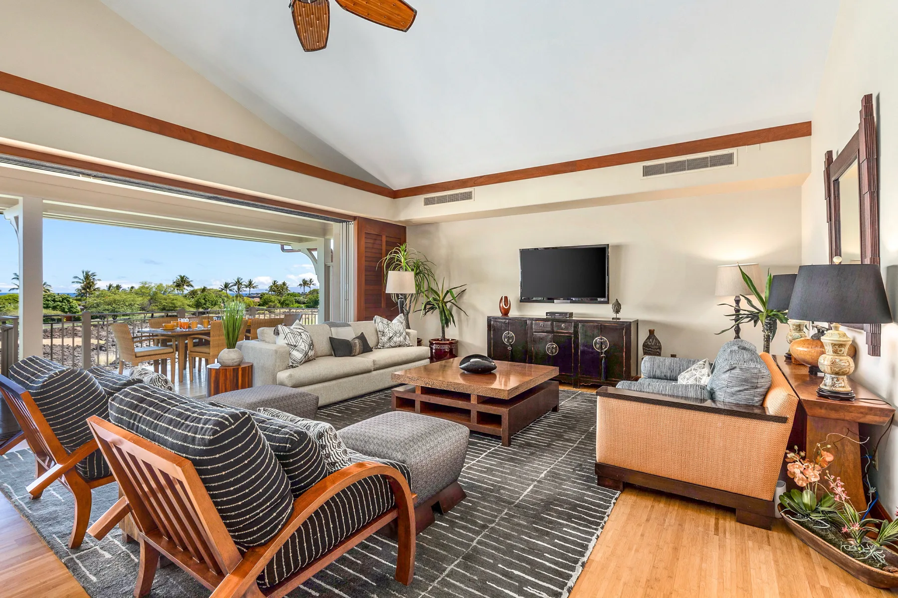 A living room with seating arranged around a coffee table and television.