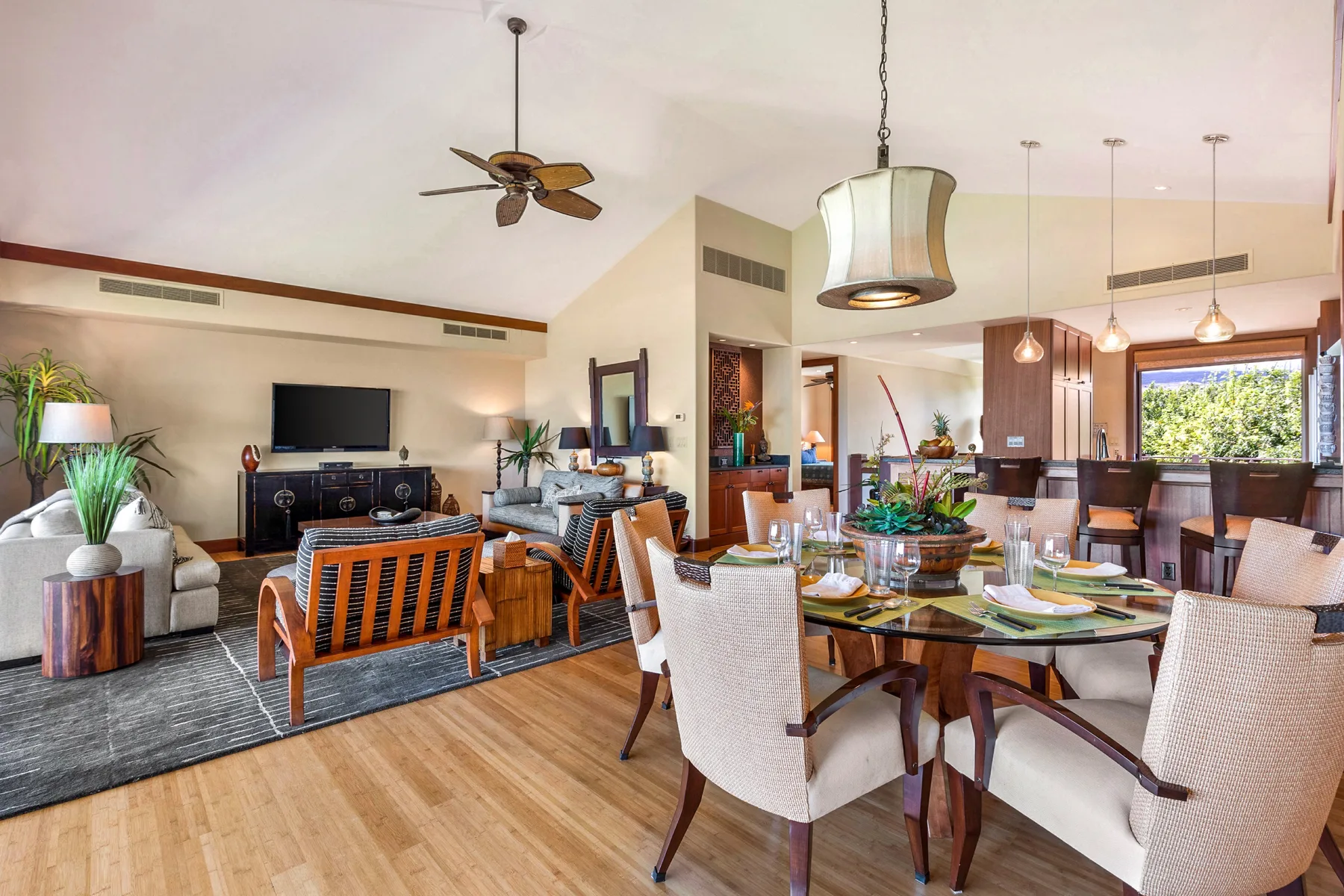 An open-plan living and dining area has seating, a television, and a dining table.