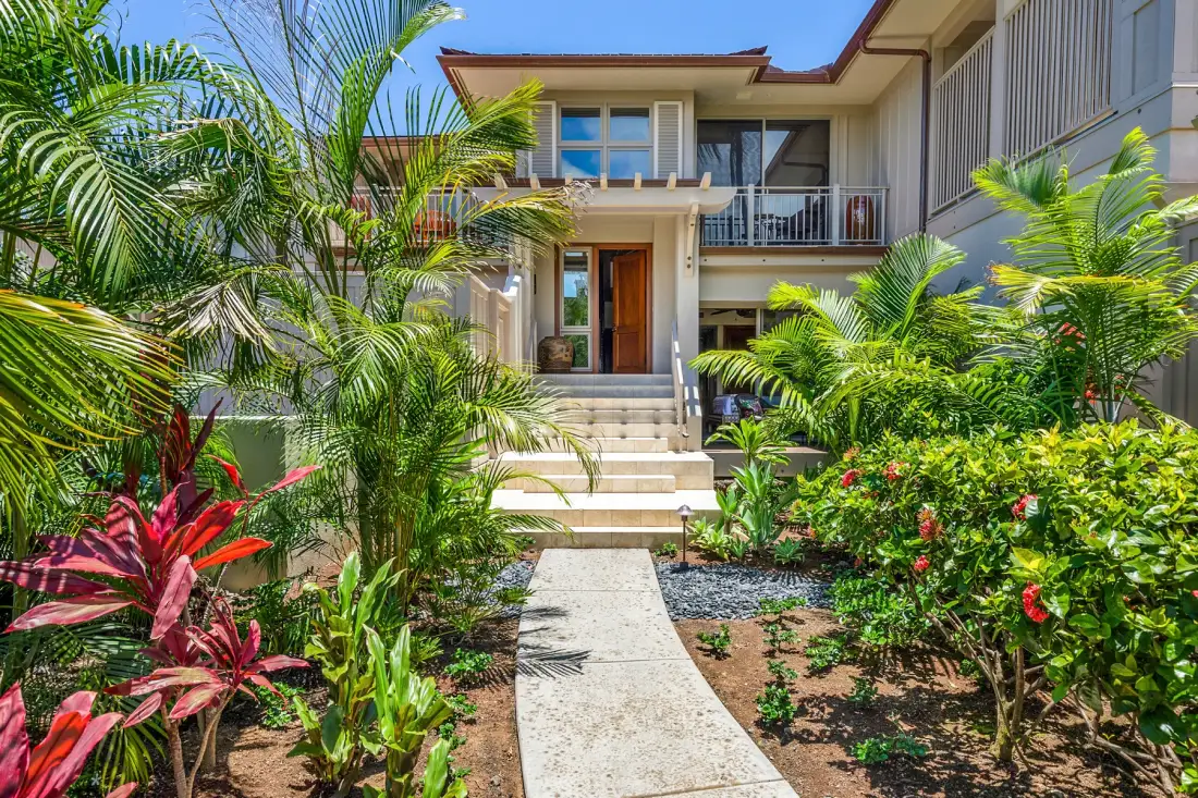 A landscaped garden path leads to the entrance of a modern house.