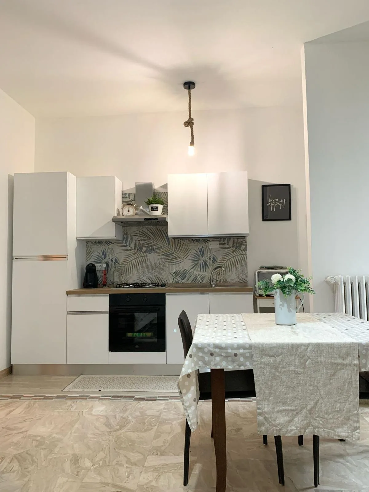 Una cocina compacta y zona de comedor con una mesa frente a los armarios.