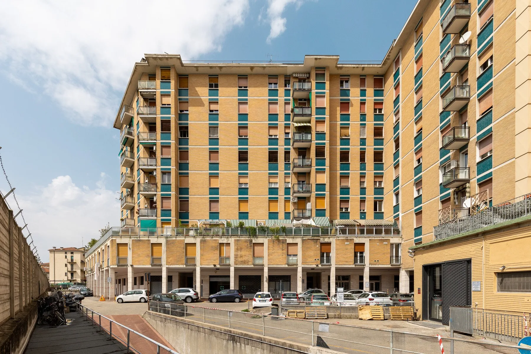 Un edificio de apartamentos de varios pisos con filas de ventanas y balcones.