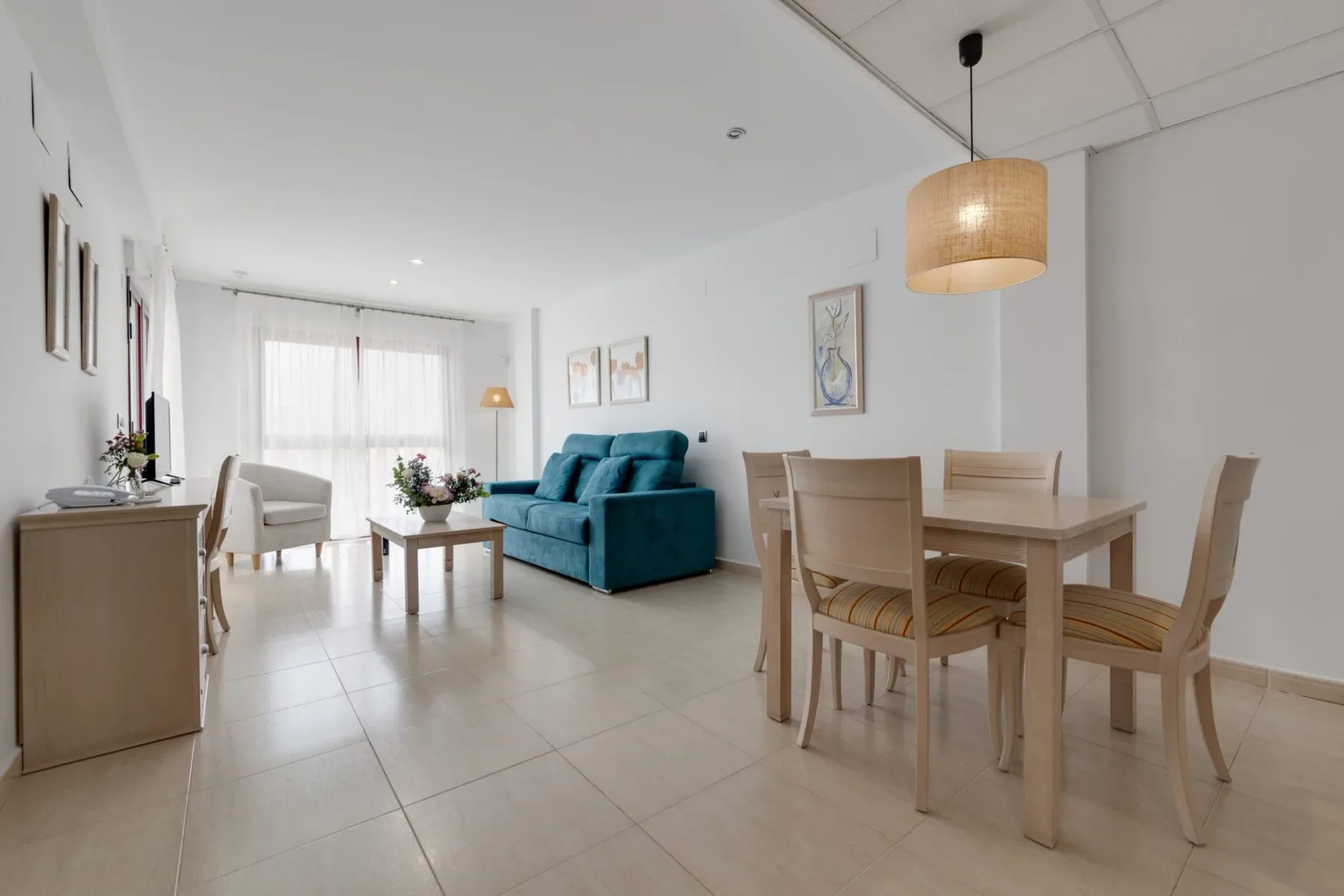 Zona de estar de la suite familiar con un sofá y una mesa de comedor.