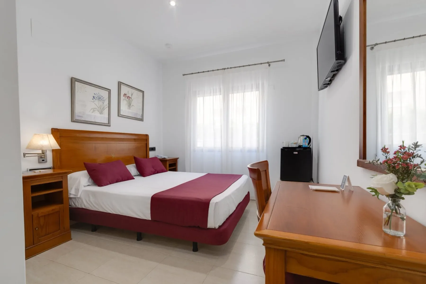 Habitación individual con una cama doble y escritorio.