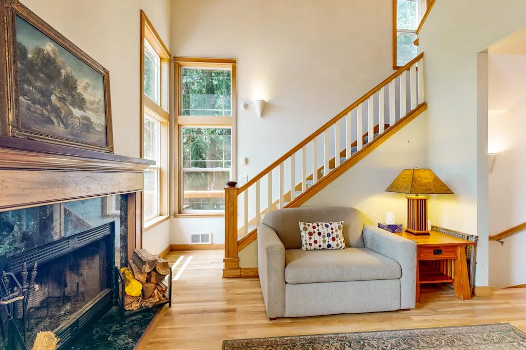 Una sala de estar con chimenea, asientos y una escalera.