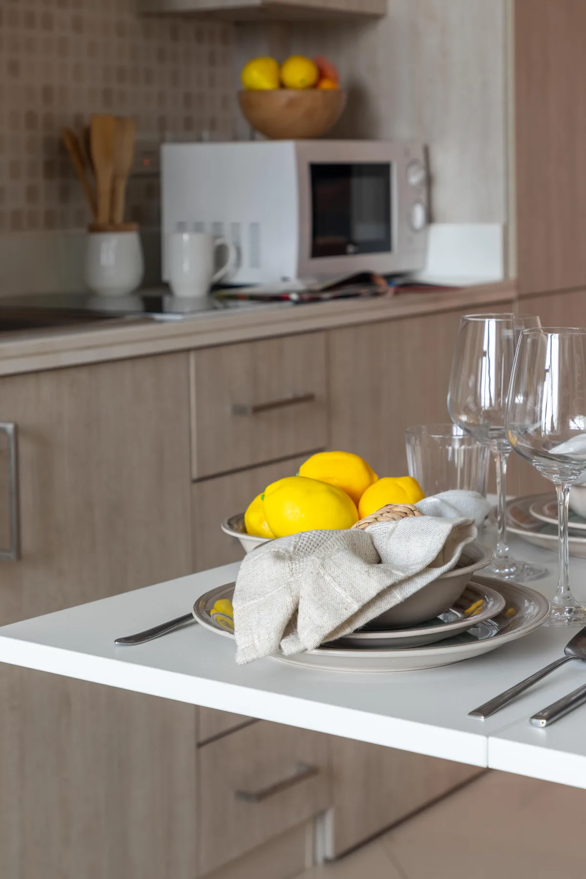 Una encimera de cocina con un cuenco de limones y un microondas.