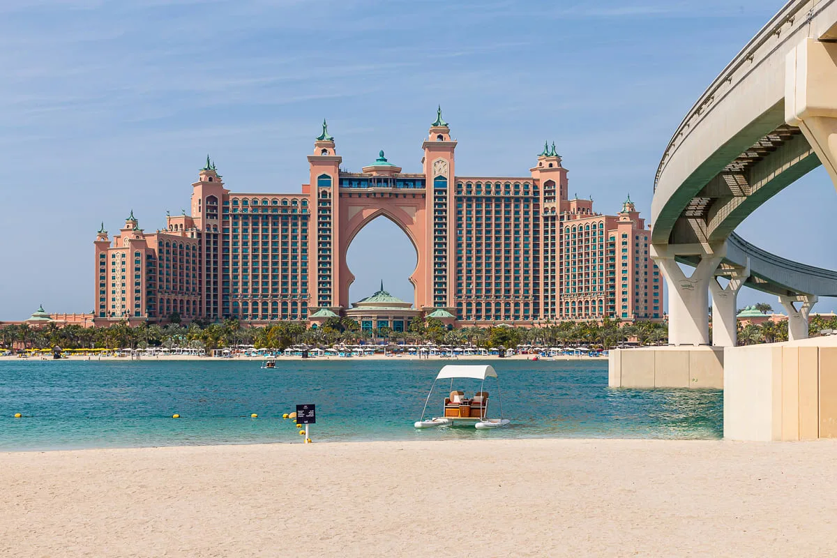 Un gran hotel frente al agua se ve al otro lado, con un puente curvo a la derecha.