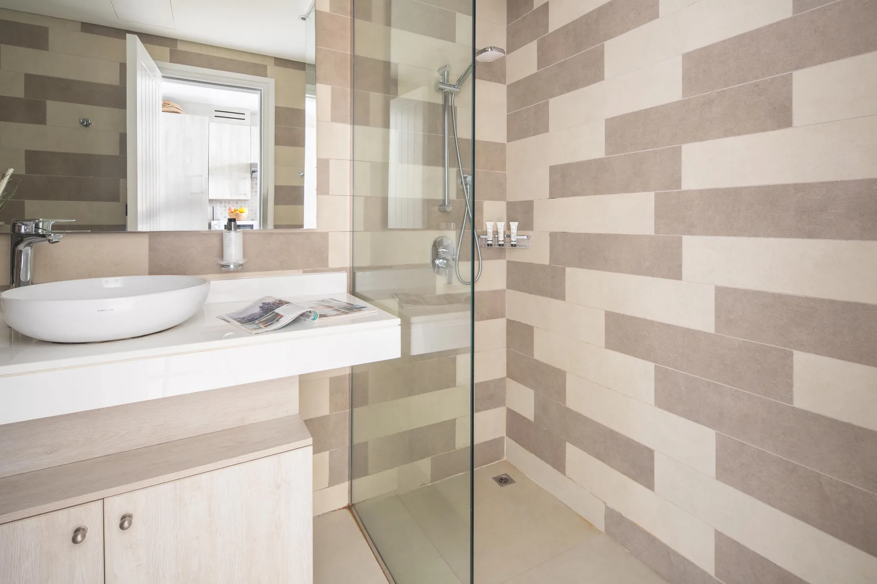 Un baño con lavabo y una ducha con panel de vidrio.