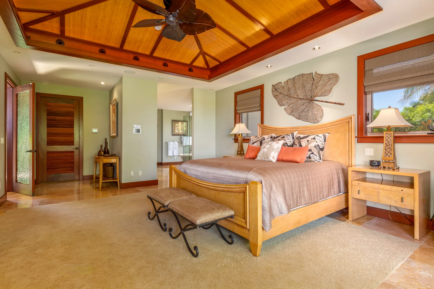 A bedroom with a wooden bed beneath a peaked wood-paneled ceiling.