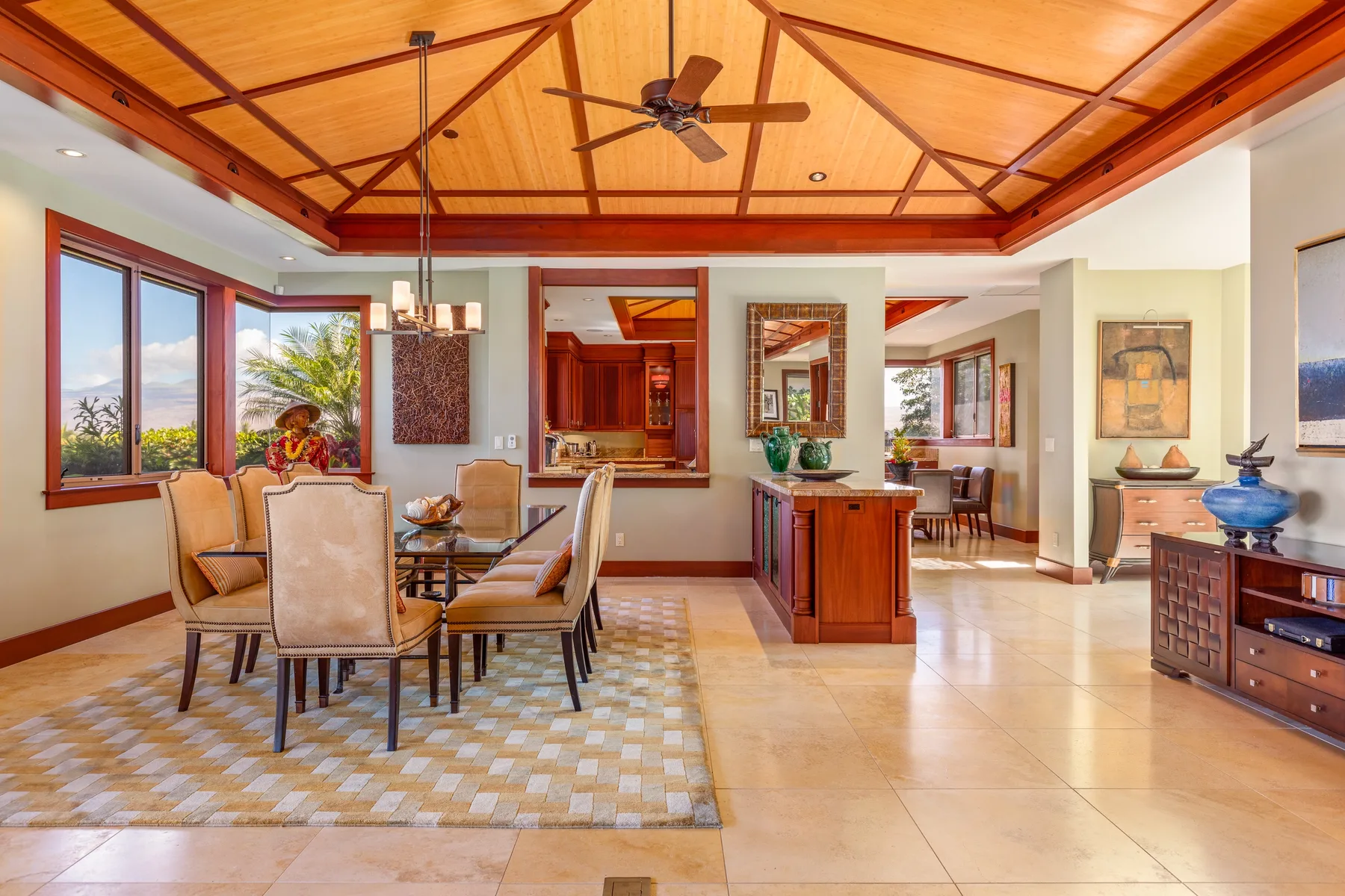 A bright open-plan dining and living area with a wood-paneled ceiling.